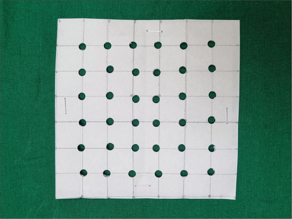 Adhesive dressing punched in a grid.